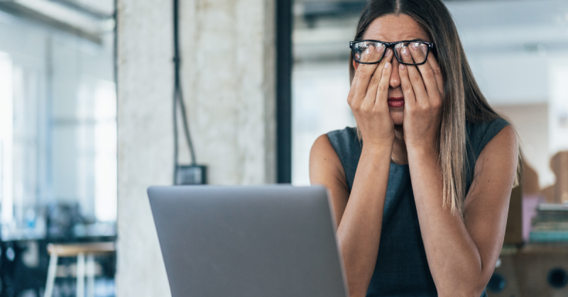 Person in front of laptop appearing stressed